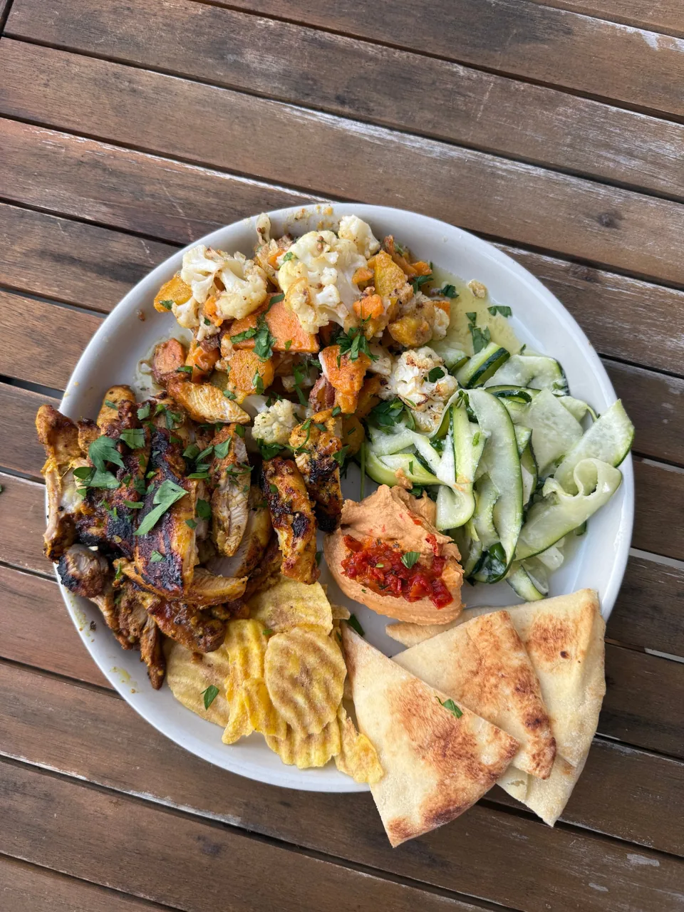 Spiced grilled chicken with roasted cauliflower, zucchini ribbons, red pepper hummus, plantain chips and pita