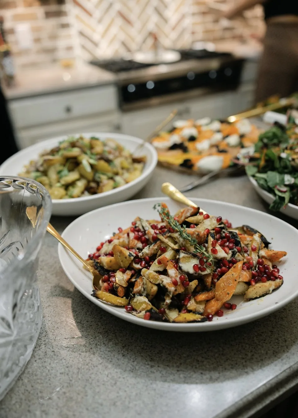 Bowl of roasted carrots and parsnips with a creamy drizzle, pomegranate seeds and thyme