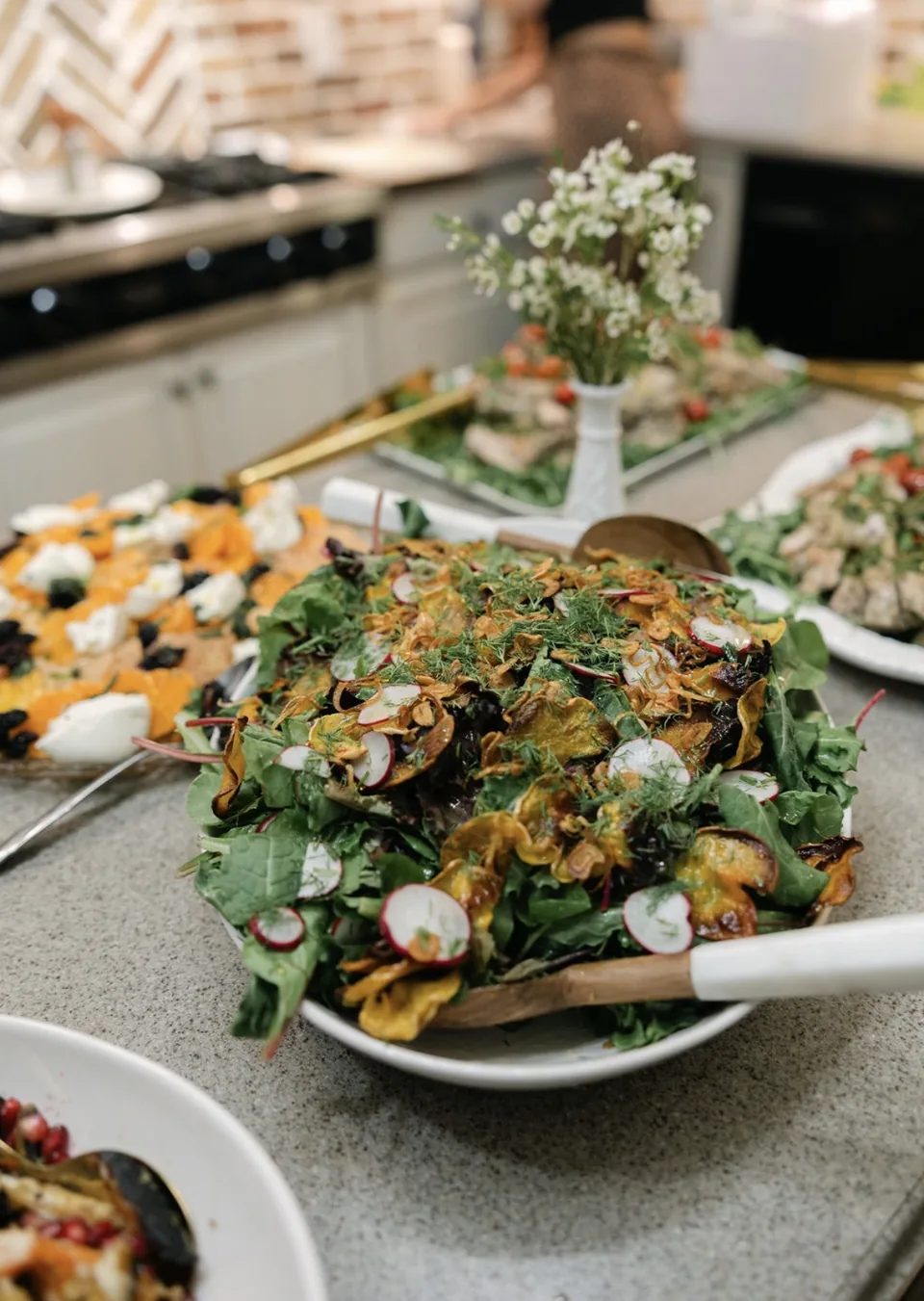 Bowl of mixed greens with radish, dill and crispy shallots on a party buffet