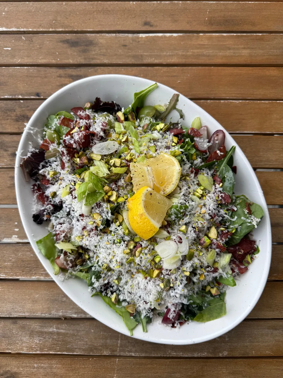 Green salad with crispy prosciutto, pistachios, scallions, grated parmesan and lemon